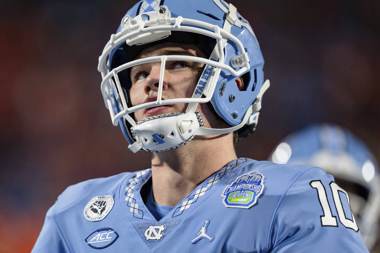 FILE - North Carolina quarterback Drake Maye warms up before the NCAA college football game against...