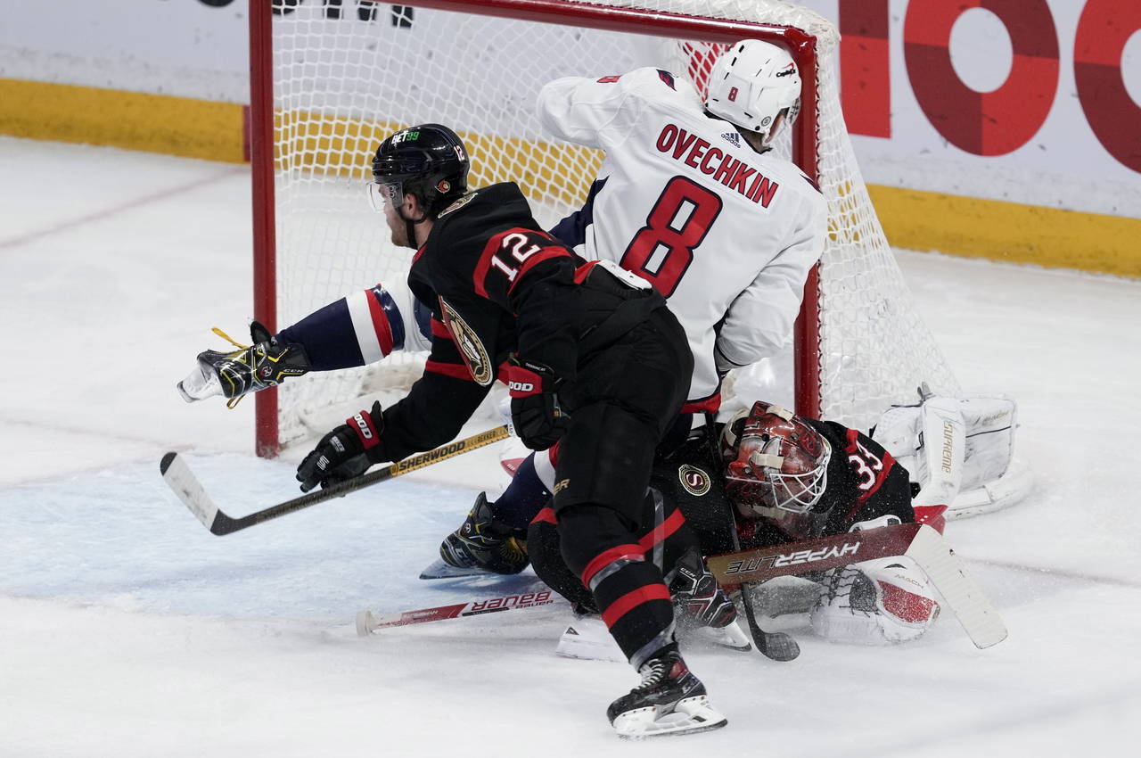 Washington Capitals left wing Alex Ovechkin (8) collides with Ottawa Senators goaltender Cam Talbot...