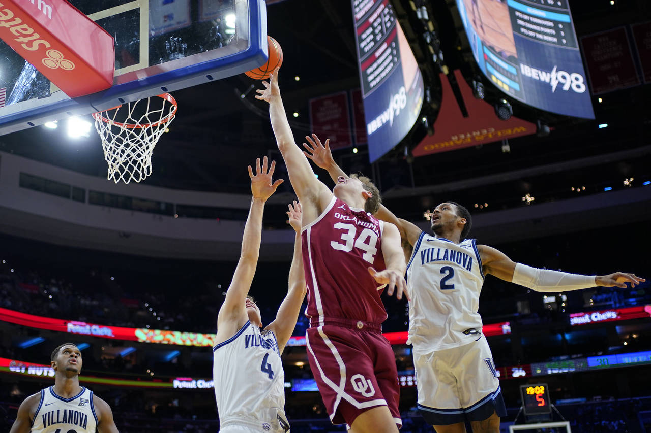Oklahoma's Jacob Groves (34) goes up for a shot between Villanova's Chris Arcidiacono (4) and Mark ...