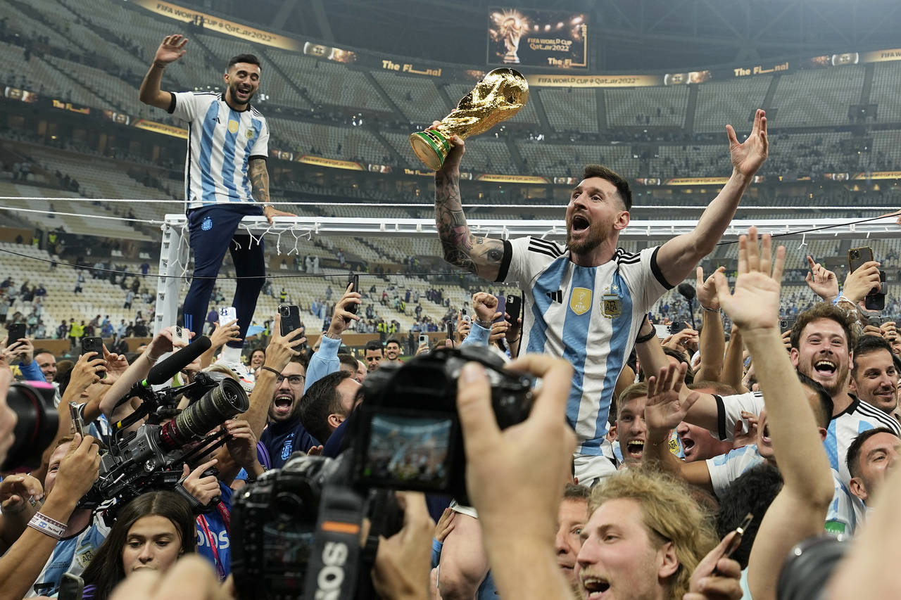 Lionel Messi celebra con el trofeo de campeón mundial con los hinchas de Argentina tras la victori...