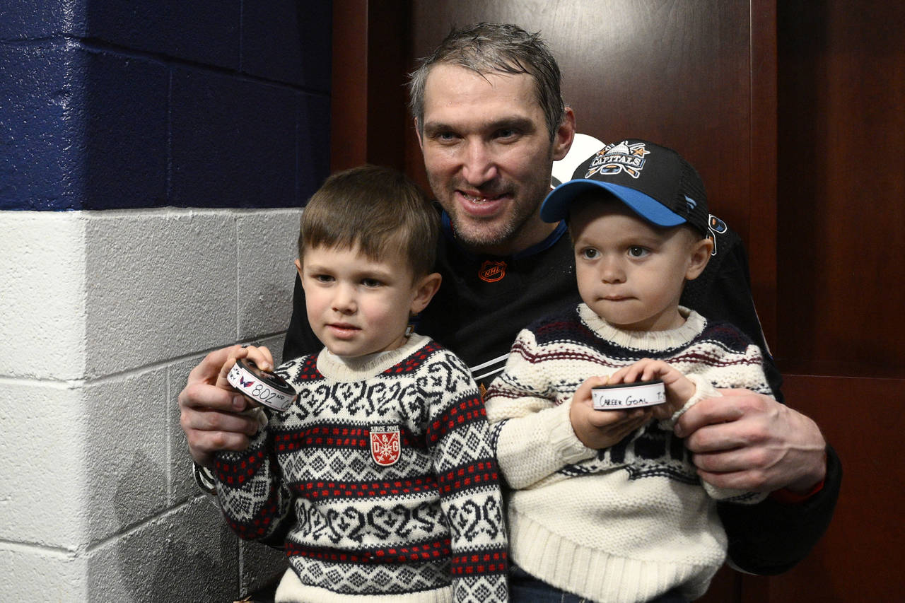 Washington Capitals left wing Alex Ovechkin, center, poses with his children Sergei, left, and Ilya...