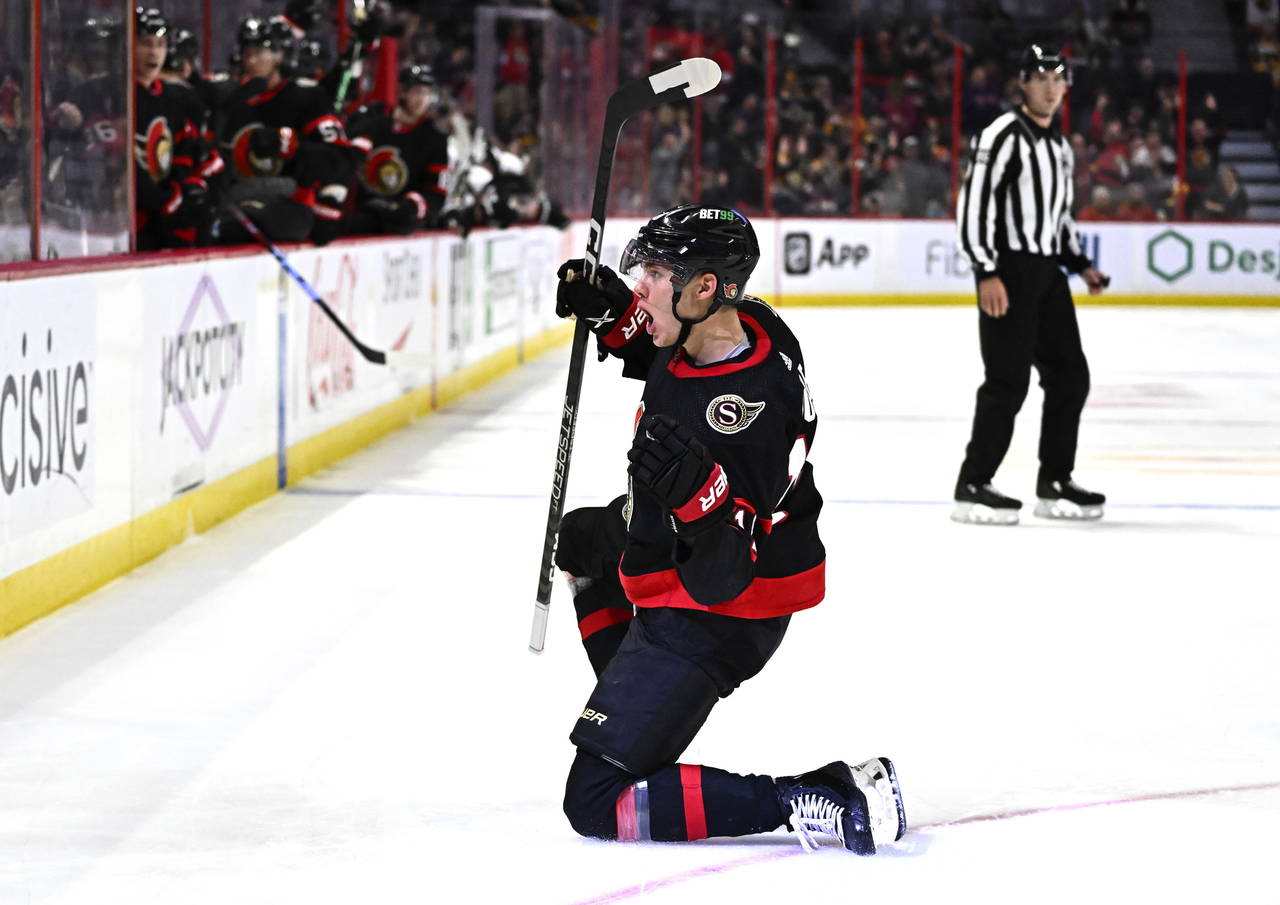 Ottawa Senators left wing Tim Stutzle slides on the ice as he celebrates his goal against the Bosto...