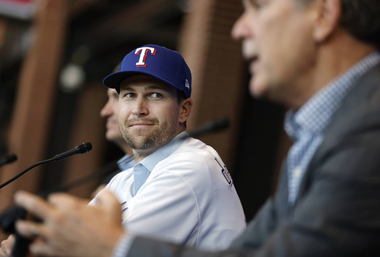 Texas Rangers starting pitcher Jacob deGrom, left, listens to new manger Bruce Bochy after trying o...