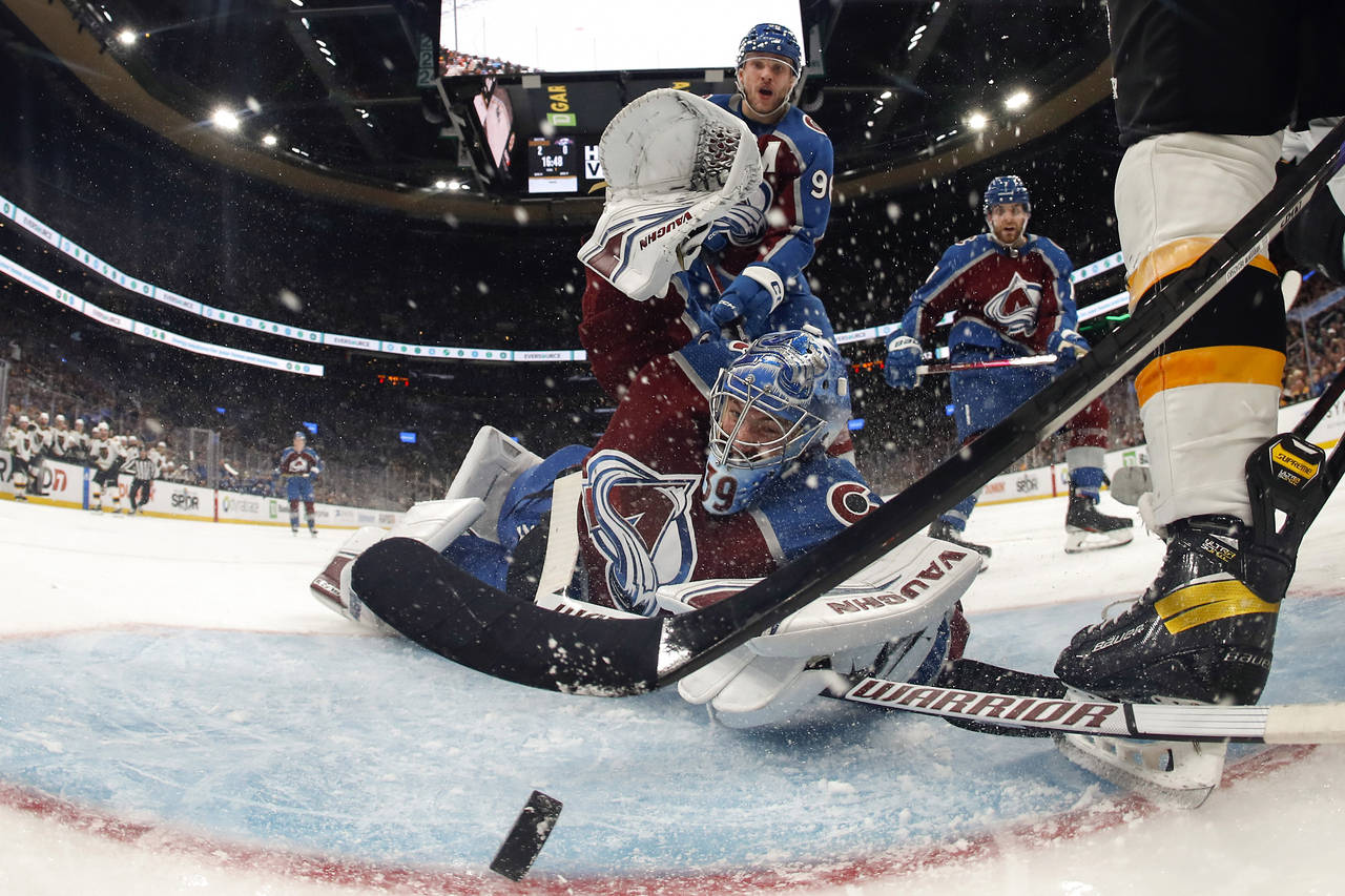 In this photo shot with a wide angle lens, Colorado Avalanche goaltender Pavel Francouz looks back ...