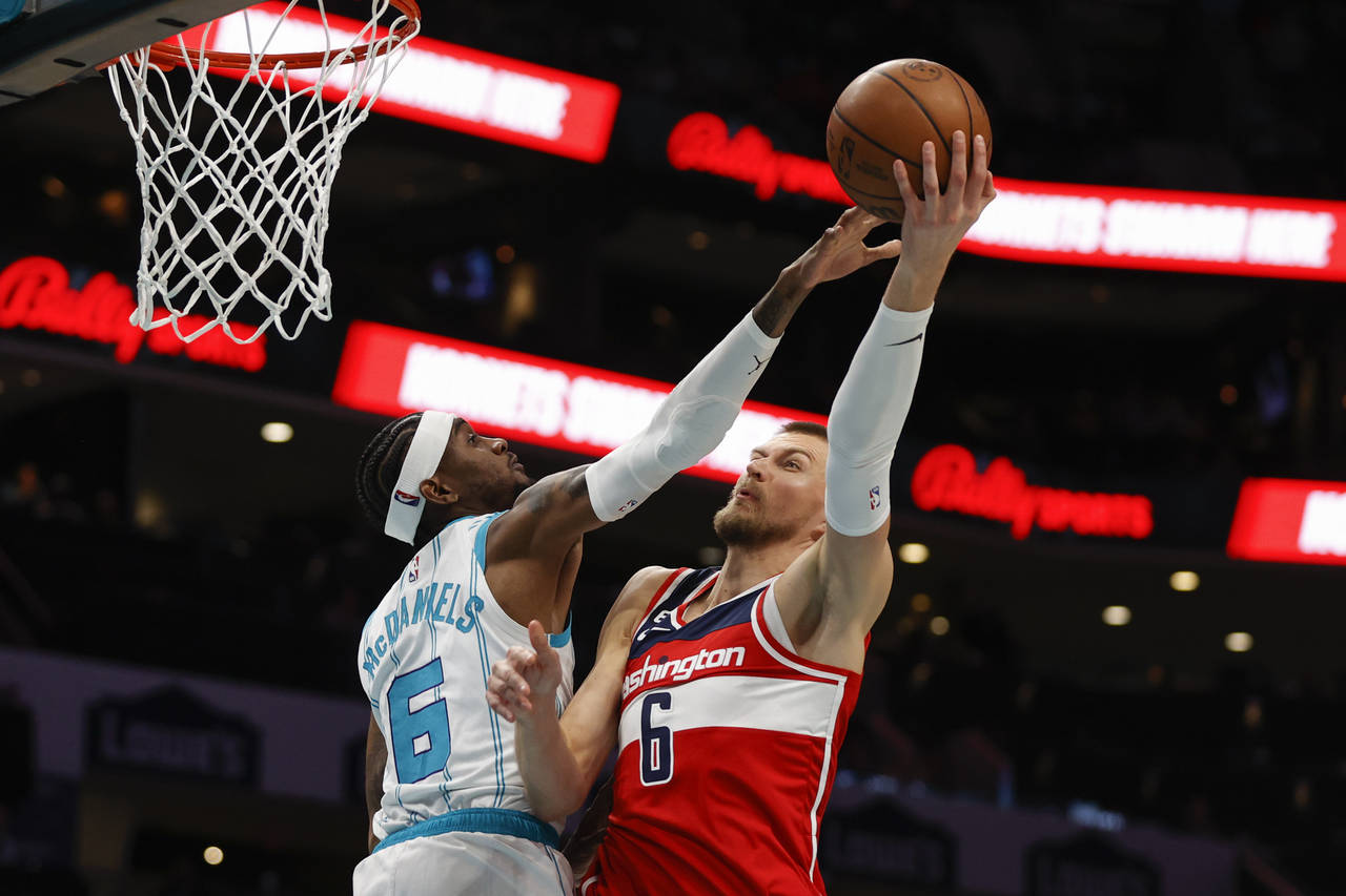 Washington Wizards center Kristaps Porzingis, right, shoots against Charlotte Hornets forward Jalen...