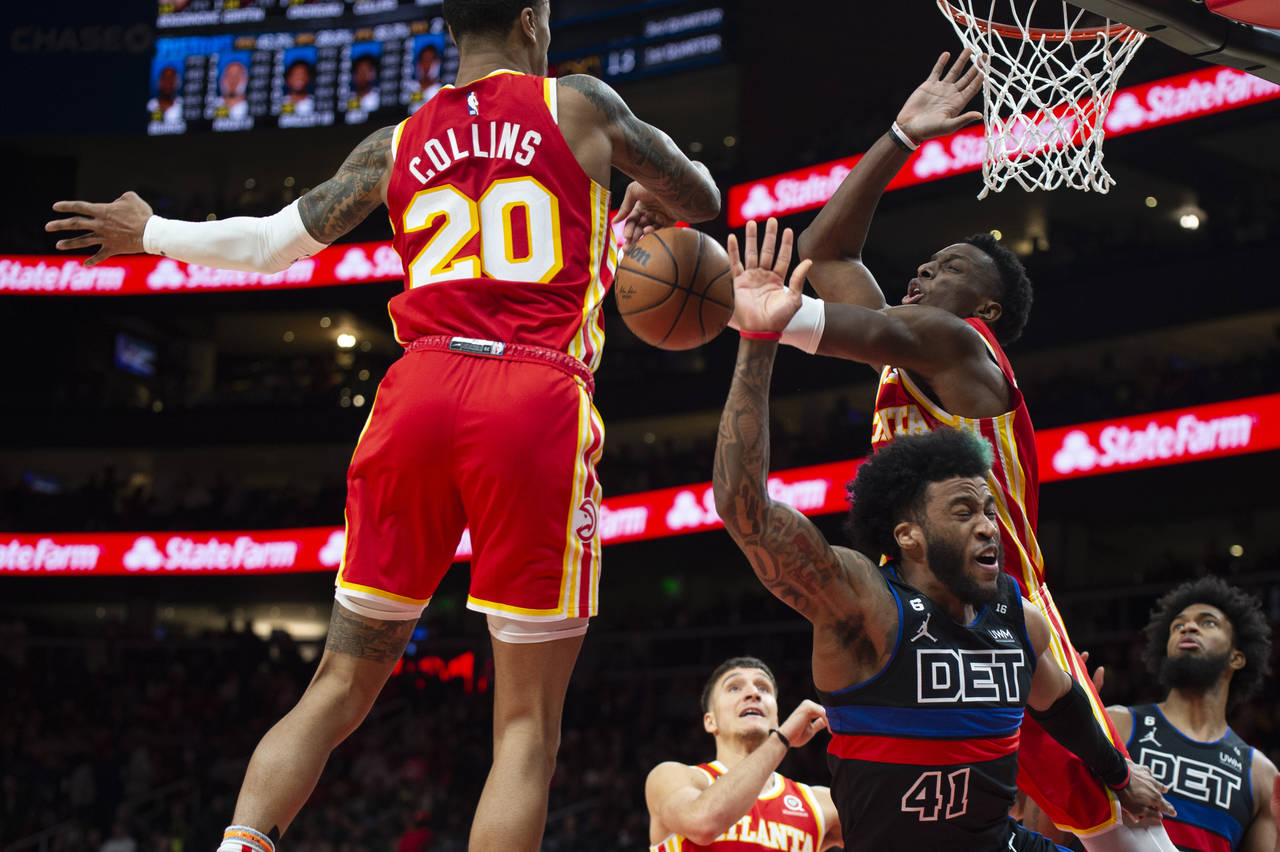Detroit Pistons forward Saddiq Bey has his shot blocked as Atlanta Hawks forward John Collins and f...