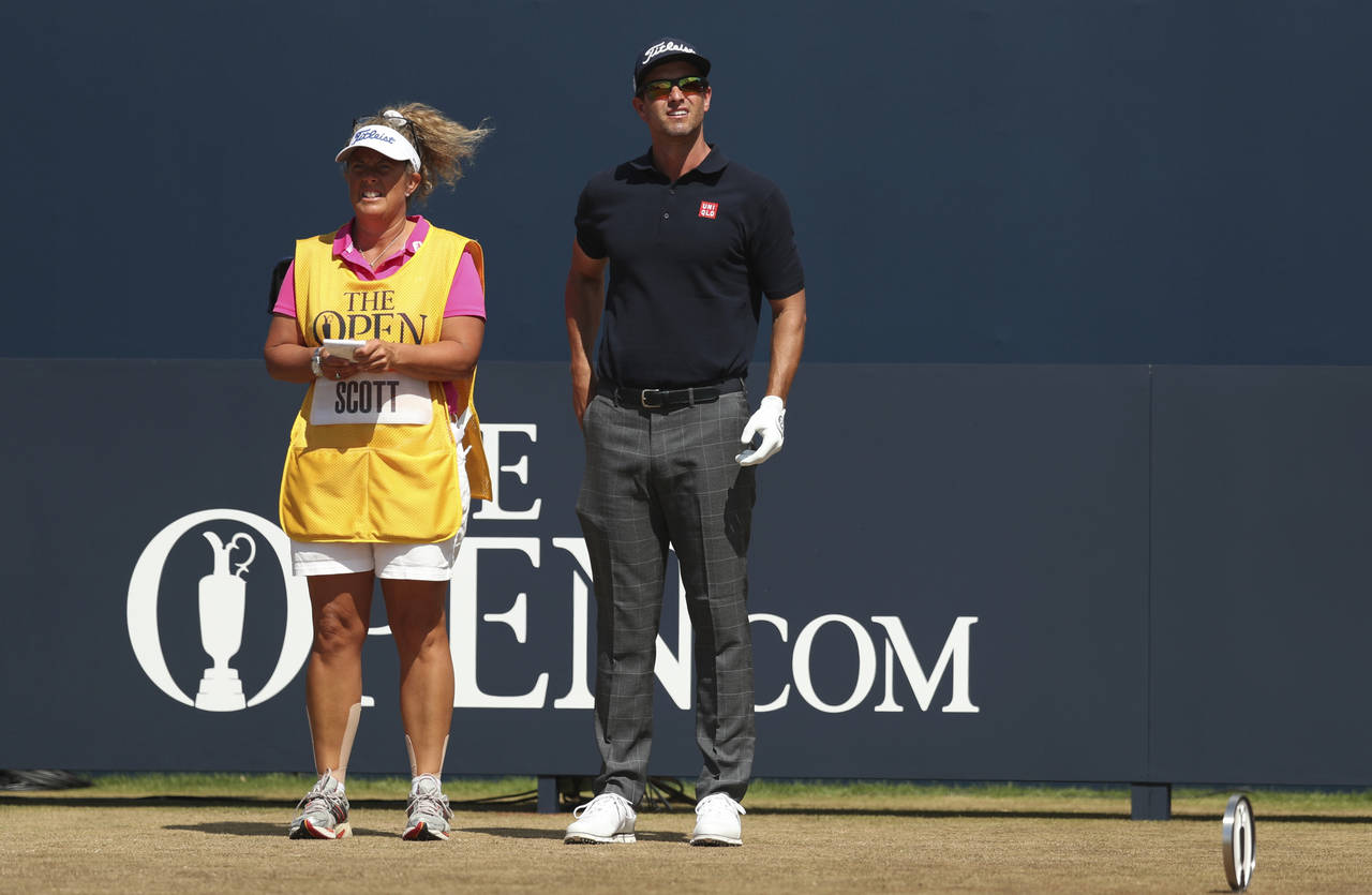 FILE - Adam Scott of Australia stands on the 1st tee box with his caddie Fanny Sunesson during the ...