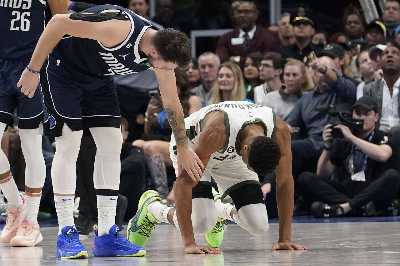 Dallas Mavericks guard Luka Doncic (77) checks on Milwaukee Bucks forward Giannis Antetokounmpo (34...