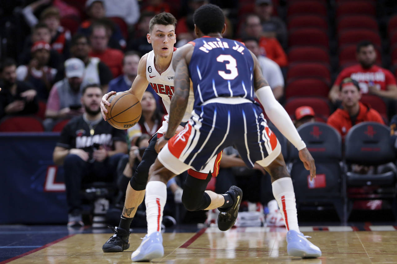 Miami Heat guard Tyler Herro, left, looks to drive around Houston Rockets guard Kevin Porter Jr. (3...