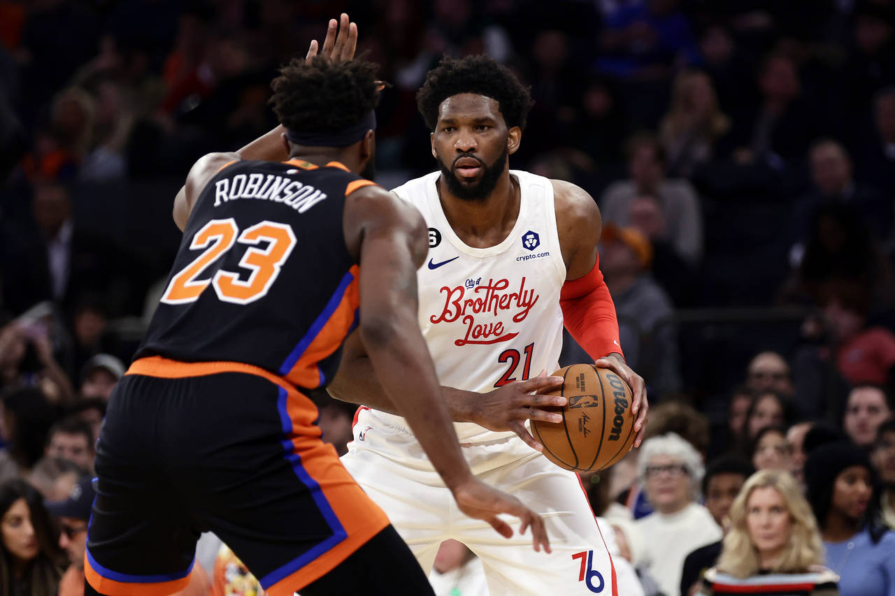 Philadelphia 76ers center Joel Embiid (21) looks to pass around New York Knicks center Mitchell Rob...