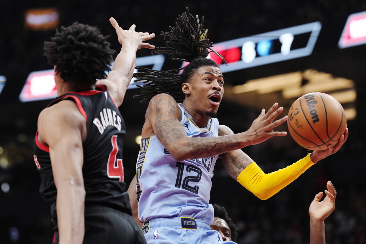 Memphis Grizzlies guard Ja Morant (12) drives to the basket past Toronto Raptors forward Scottie Ba...