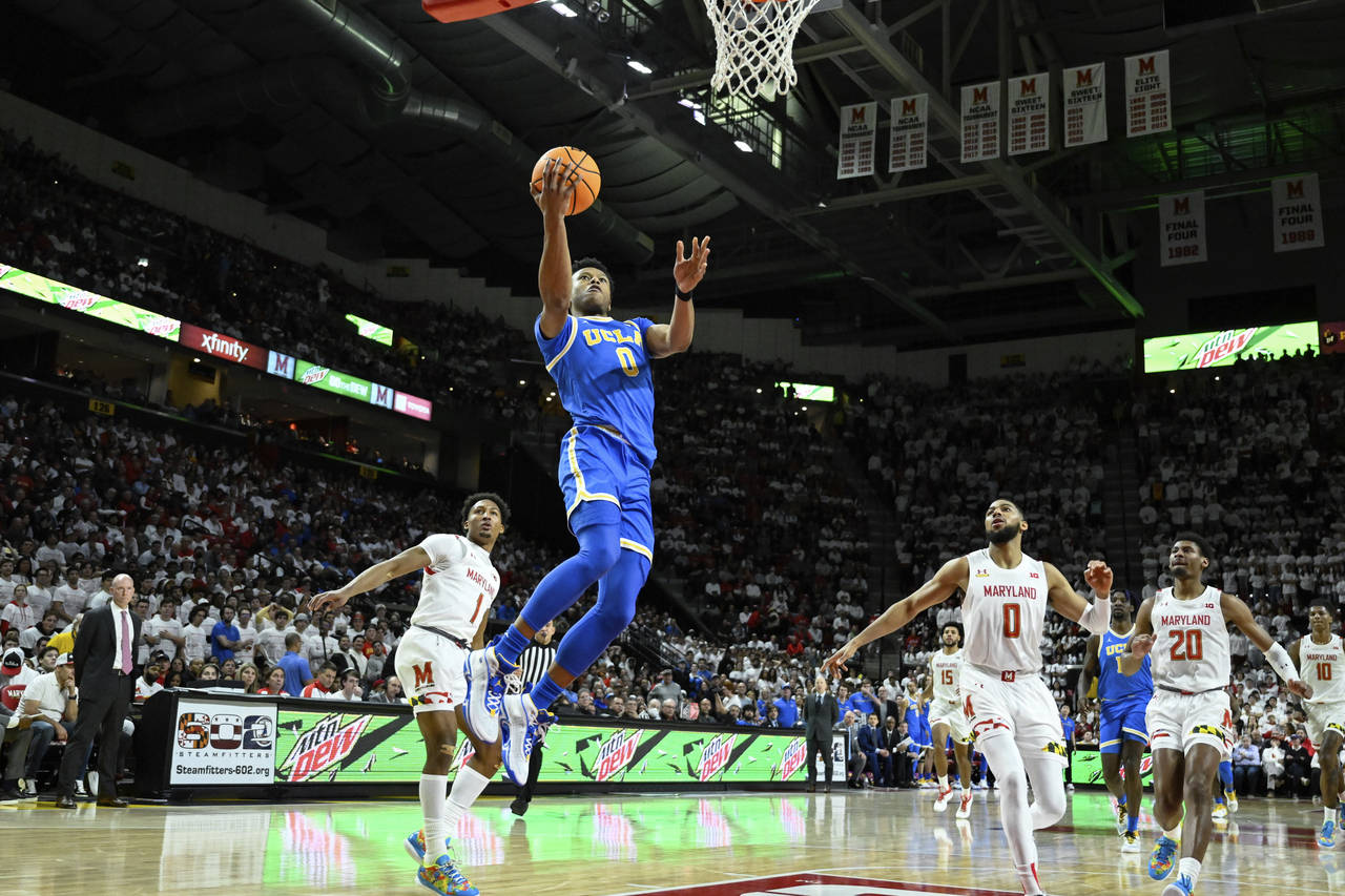 UCLA guard Jaylen Clark (0) goes to the basket for lay up and is fouled by Maryland guard Jahmir Yo...