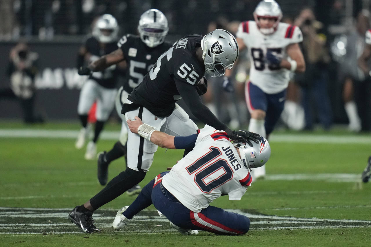 Las Vegas Raiders defensive end Chandler Jones (55) breaks a tackle by New England Patriots quarter...