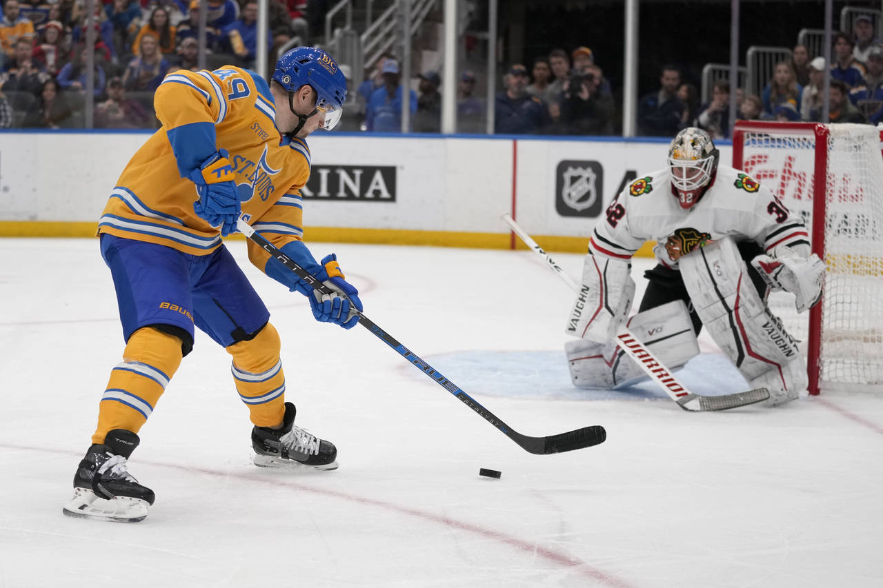 St. Louis Blues' Ivan Barbashev, left, controls the puck as Chicago Blackhawks goaltender Alex Stal...