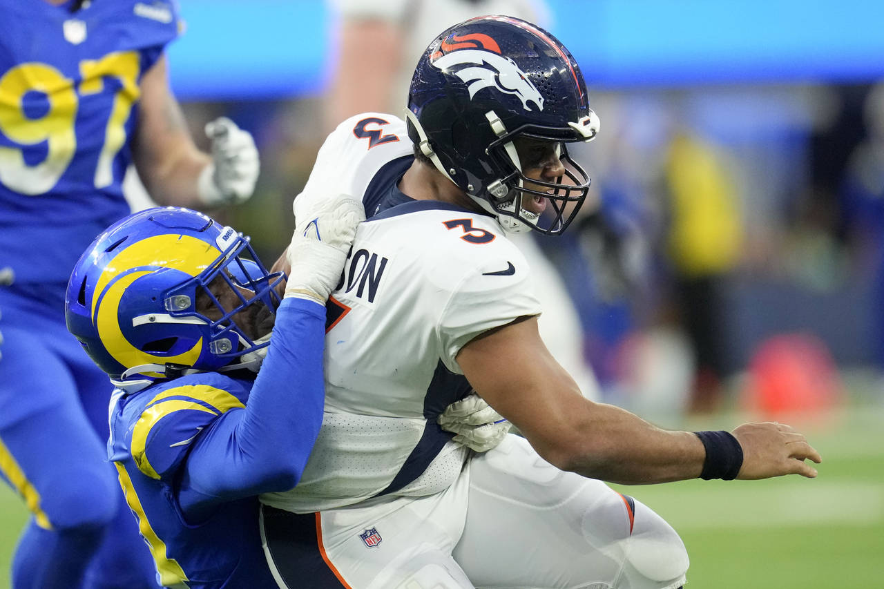Denver Broncos quarterback Russell Wilson is tackled by Los Angeles Rams linebacker Leonard Floyd d...