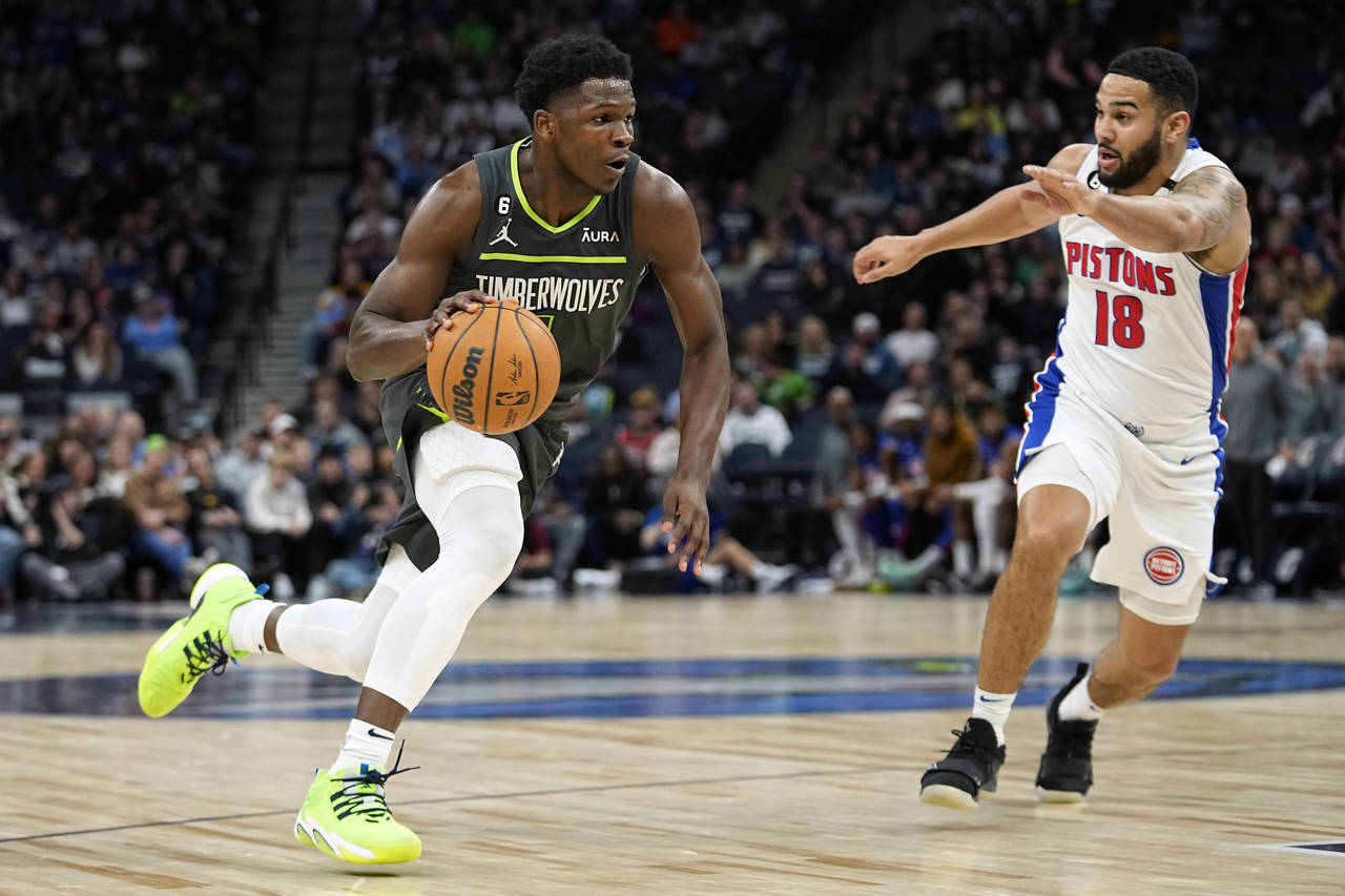Minnesota Timberwolves guard Anthony Edwards (1) works towards the basket while defended by Detroit...
