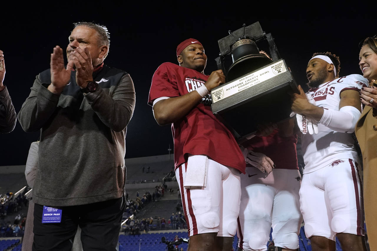 Arkansas coach Sam Pittman, left, applauds as quarterback KJ Jefferson, center, and defensive back ...