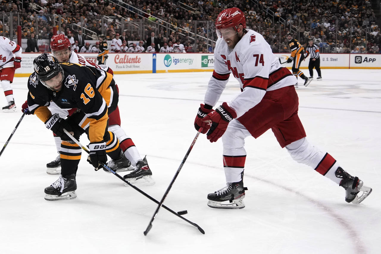 Carolina Hurricanes' Jaccob Slavin (74) knocks the puck off the stick of Pittsburgh Penguins' Jason...