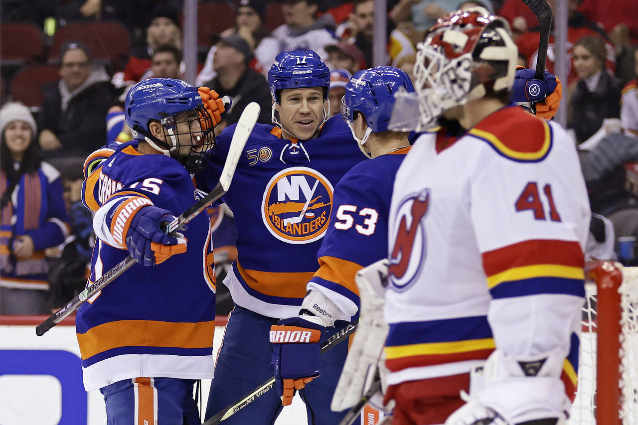 New York Islanders center Casey Cizikas (53) is congratulated by Matt Martin (17) and Cal Clutterbu...