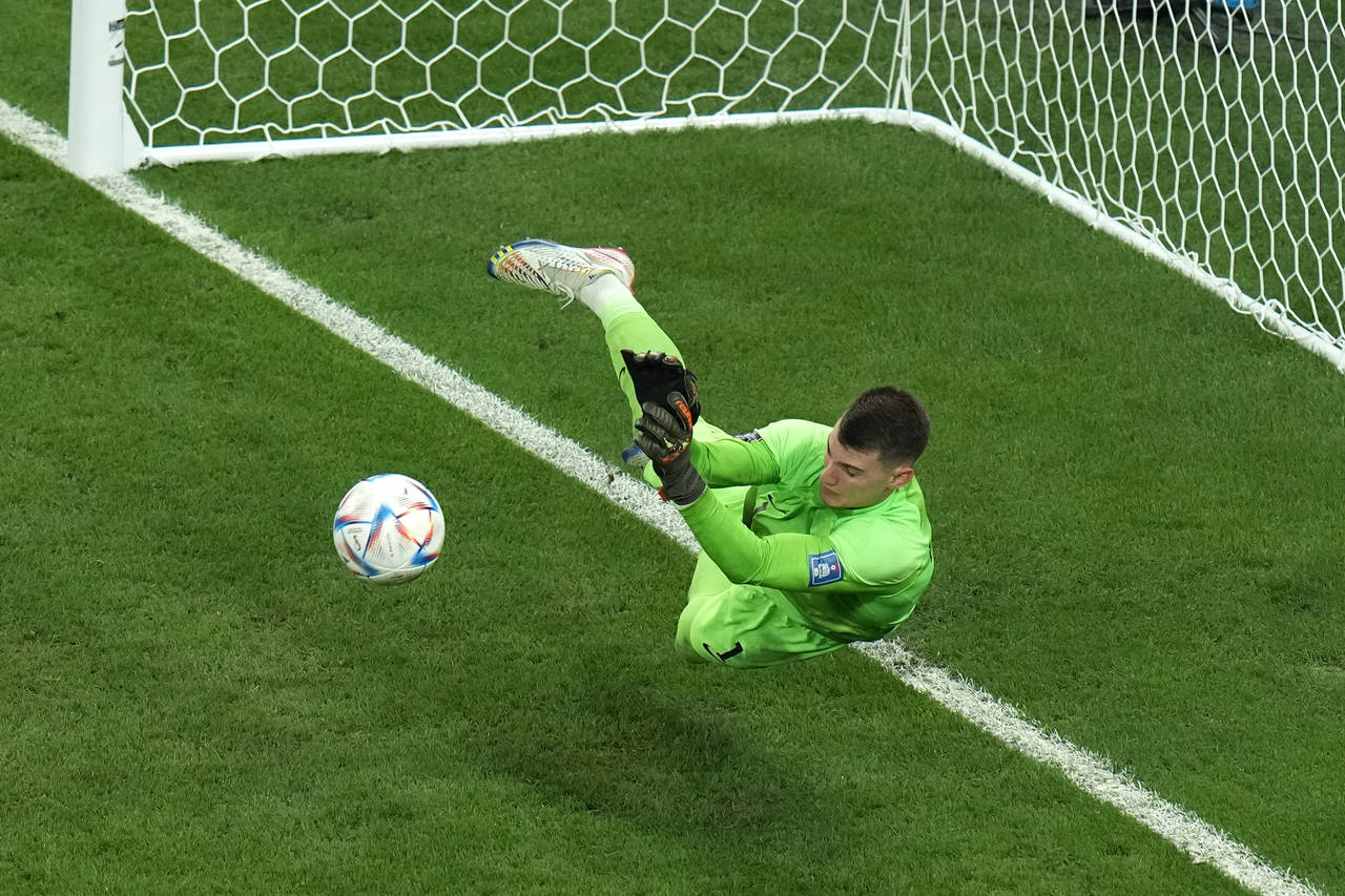 Croatia's goalkeeper Dominik Livakovic saves a ball during the penalty shoot out at the World Cup q...