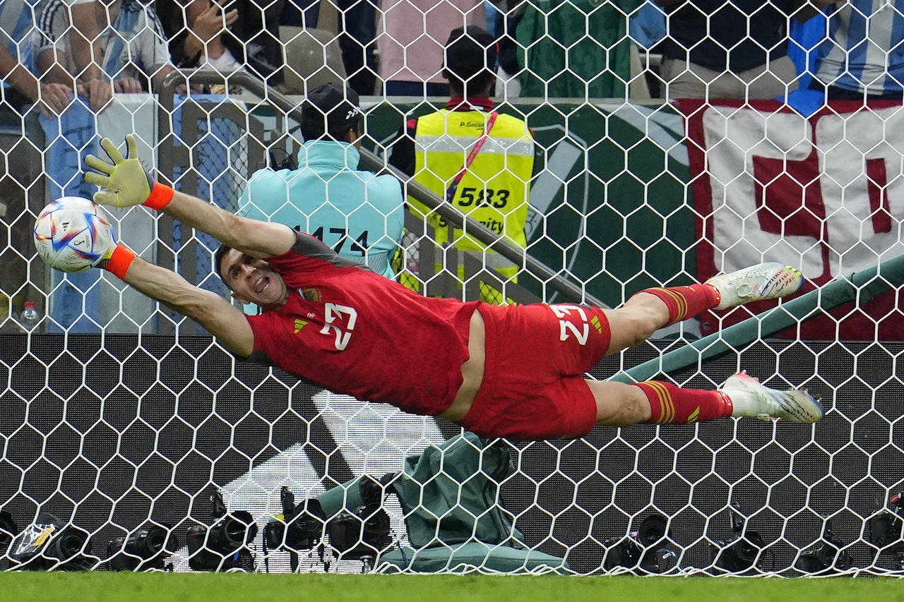 Argentina's goalkeeper Emiliano Martinez saves a kick of Virgil van Dijk of the Netherlands during ...