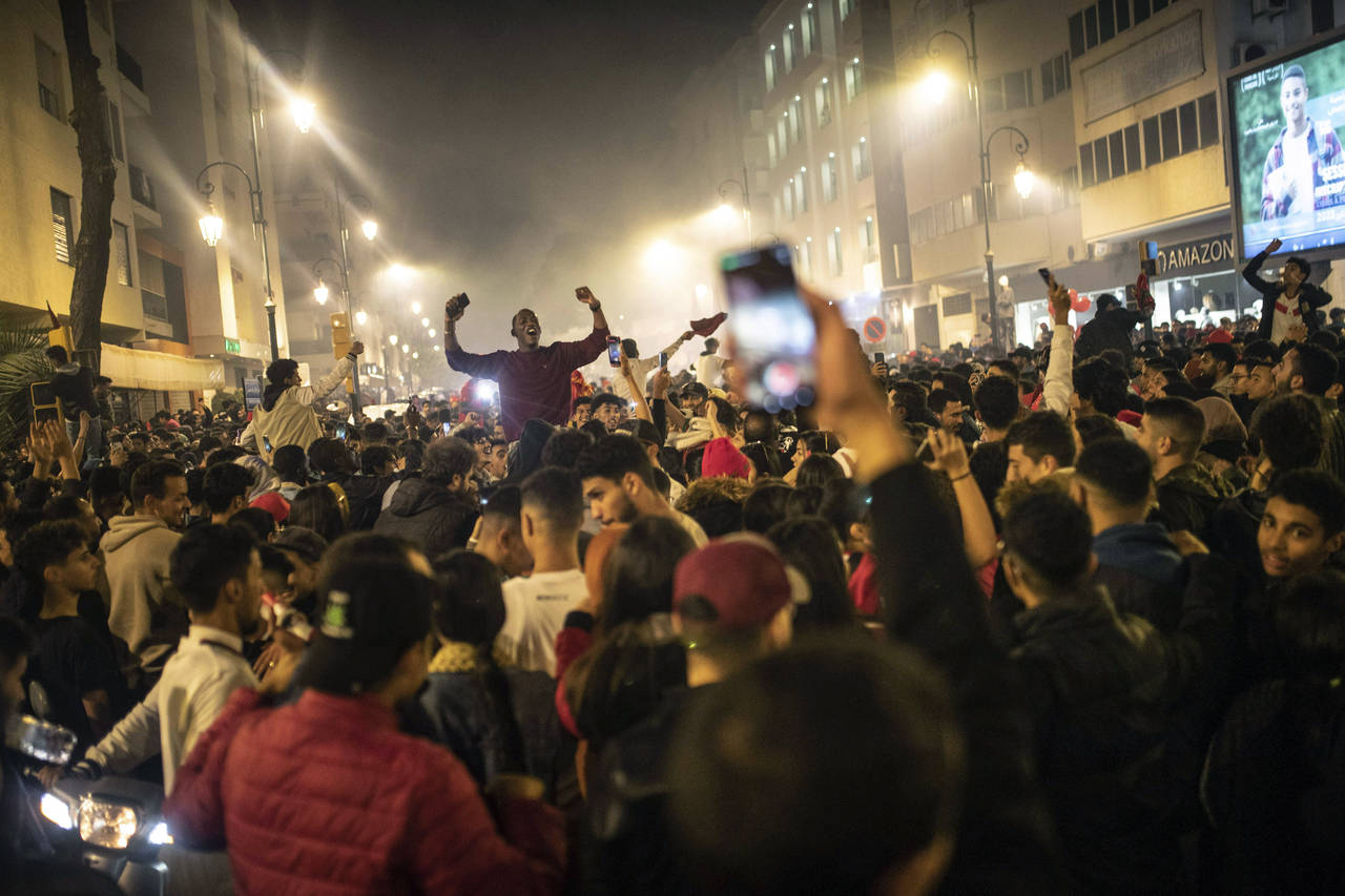 People celebrate Morocco's win over Spain in a World Cup match played in Qatar, in Rabat, Morocco, ...