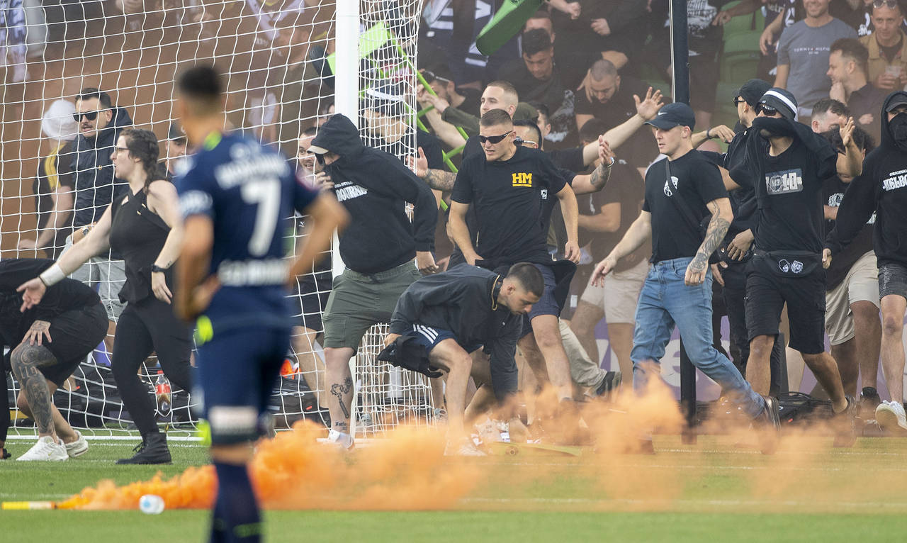 Melbourne Victory fans invade the pitch during the A-League Men's soccer match between Melbourne Ci...