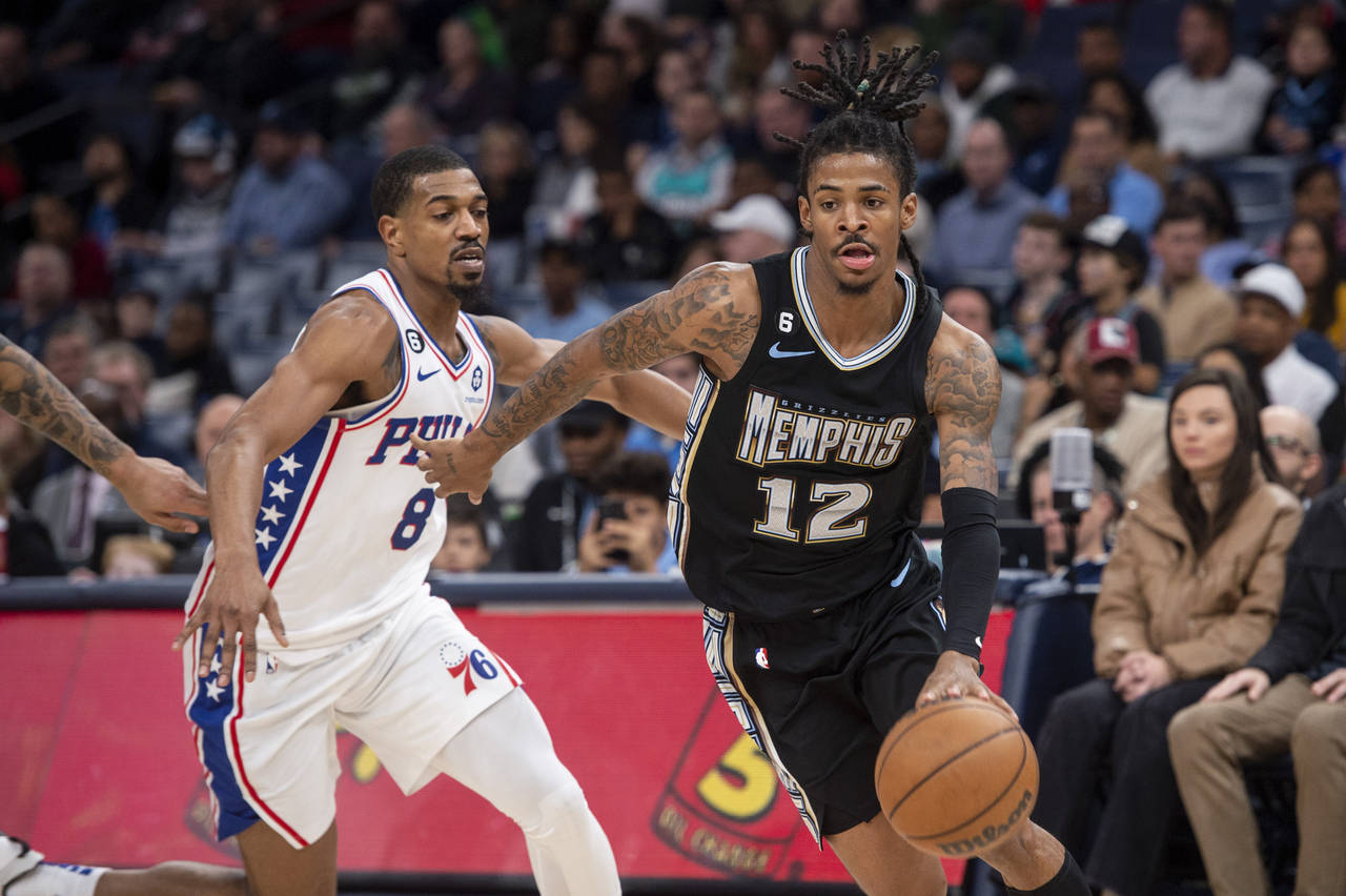 Memphis Grizzlies guard Ja Morant (12) handles the ball ahead of Philadelphia 76ers guard De'Anthon...