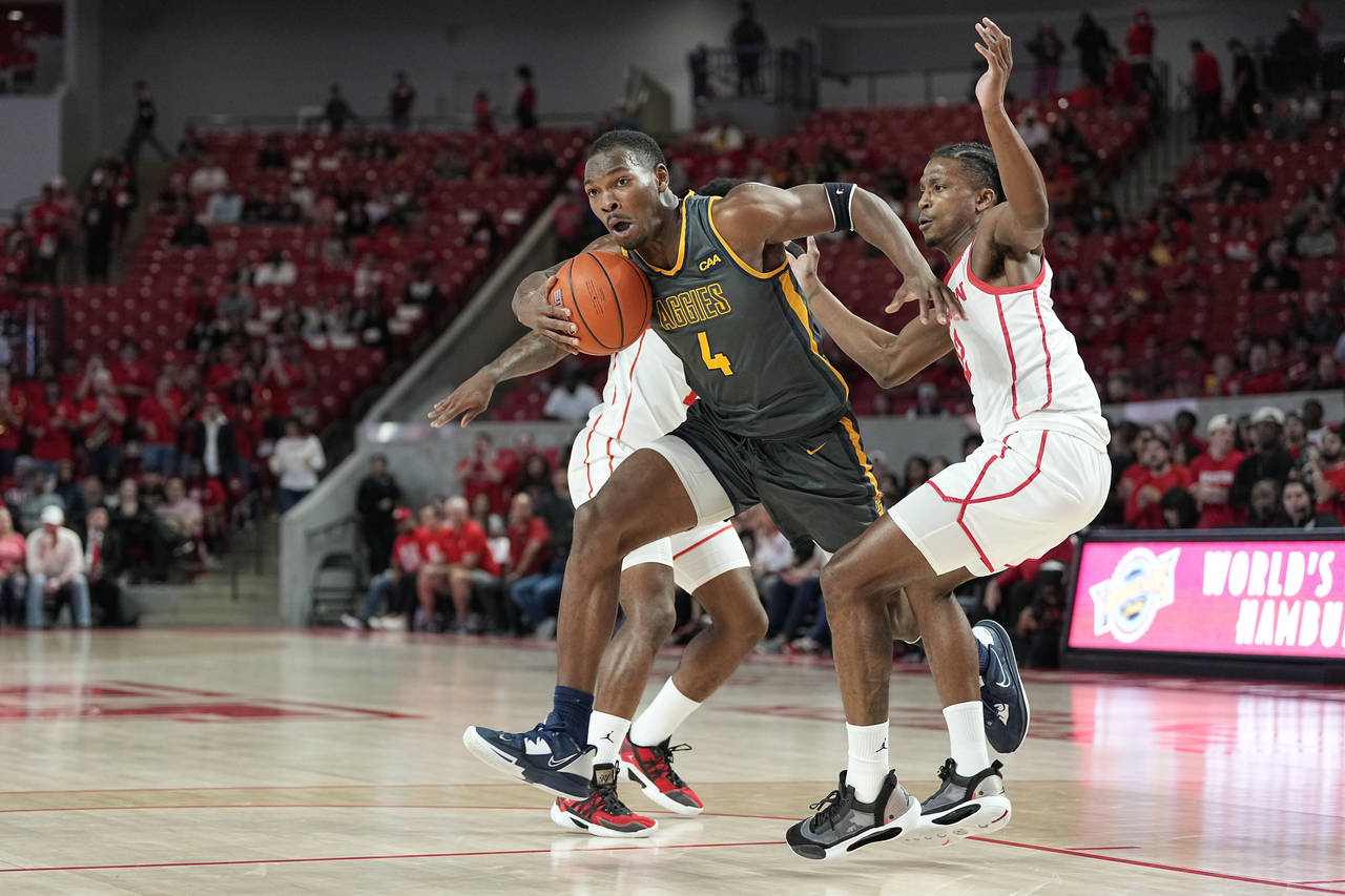 North Carolina A&T forward Marcus Watson (4) bursts through a double-team by Houston guards Tramon ...