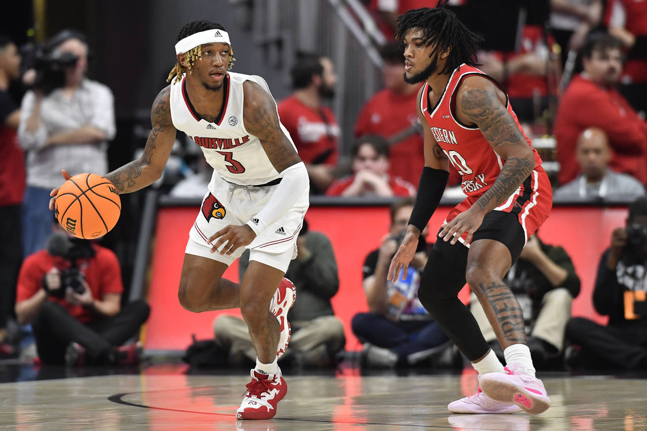 Louisville guard El Ellis (3) moves the ball around Western Kentucky guard Dayvion McKnight (20) du...
