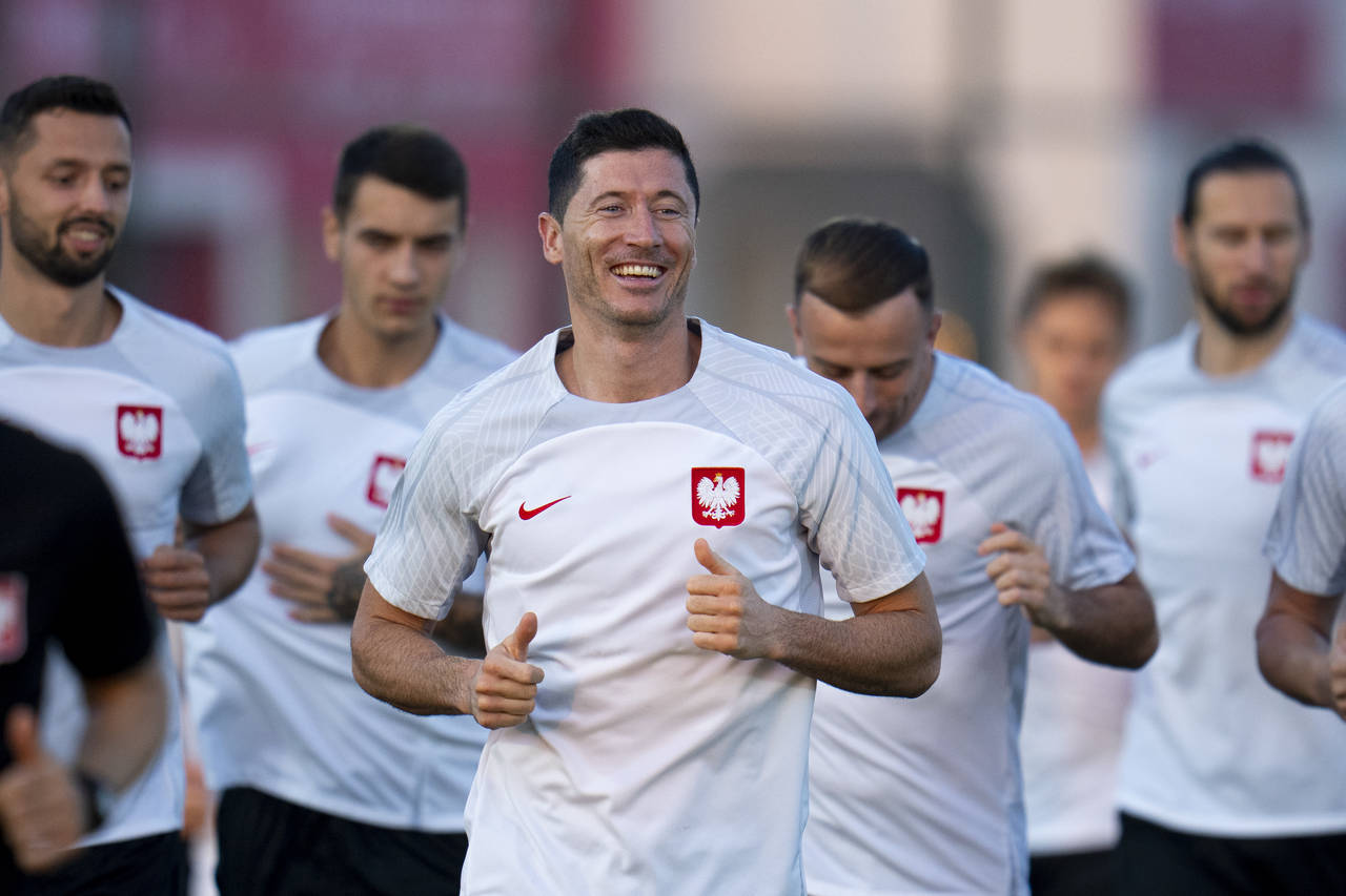 Poland's Robert Lewandowski, center, works out with teammates during a training session in Doha, Qa...