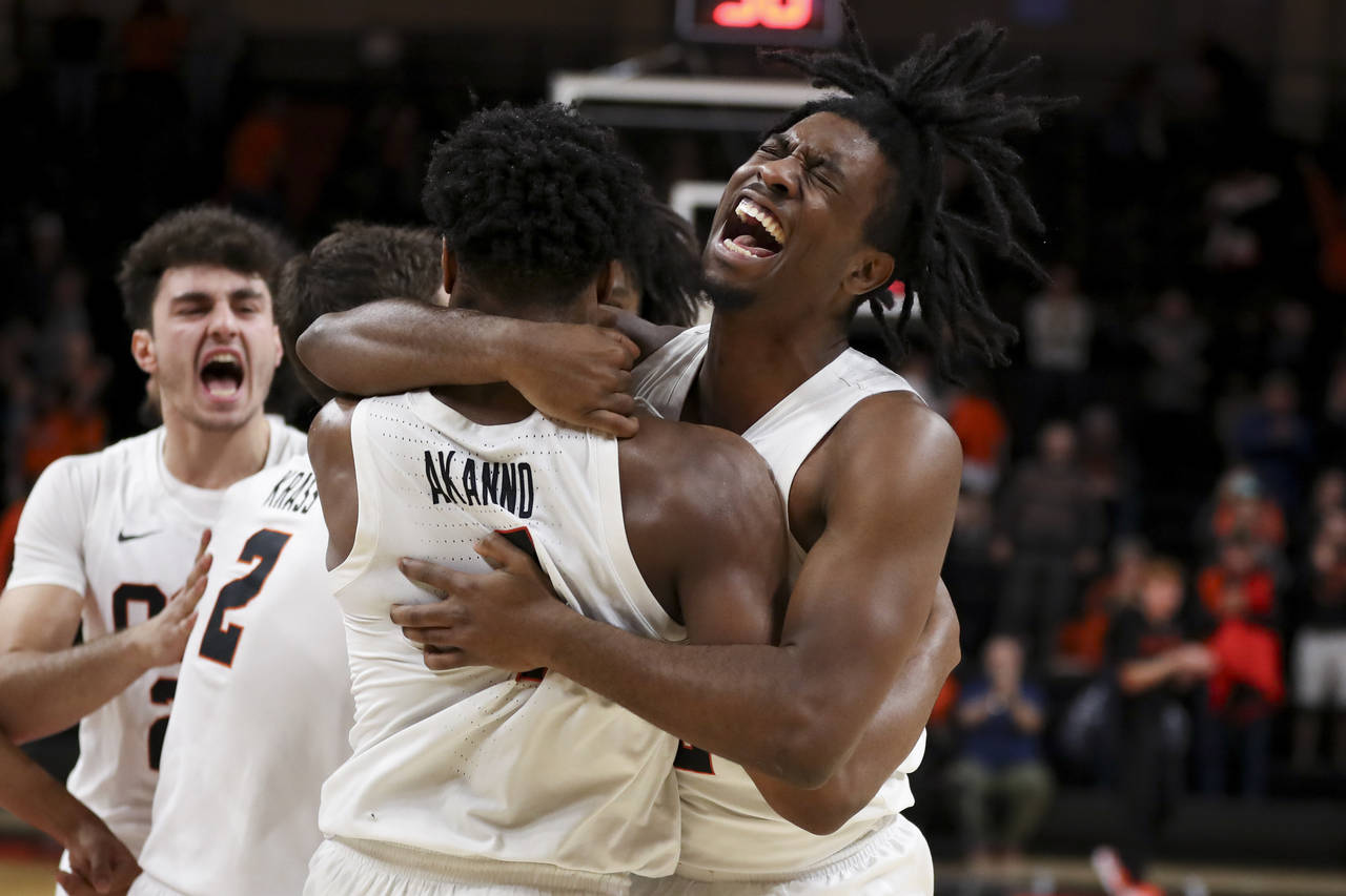 Oregon State guard Donovan Grant, right, hugs Dexter Akanno while celebrating the team's 66-65 win ...