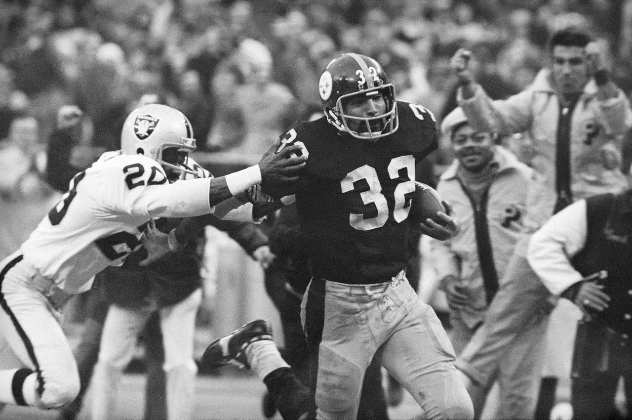 FILE - Pittsburgh Steelers' Franco Harris (32) eludes a tackle by Oakland Raiders' Jimmy Warren as ...