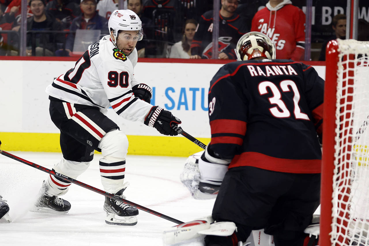 Chicago Blackhawks' Tyler Johnson (90) has his shot blocked by Carolina Hurricanes goaltender Antti...