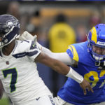 
              Los Angeles Rams defensive tackle Michael Hoecht (97) sacks Seattle Seahawks quarterback Geno Smith (7) during the first half of an NFL football game Sunday, Dec. 4, 2022, in Inglewood, Calif. (AP Photo/Mark J. Terrill)
            