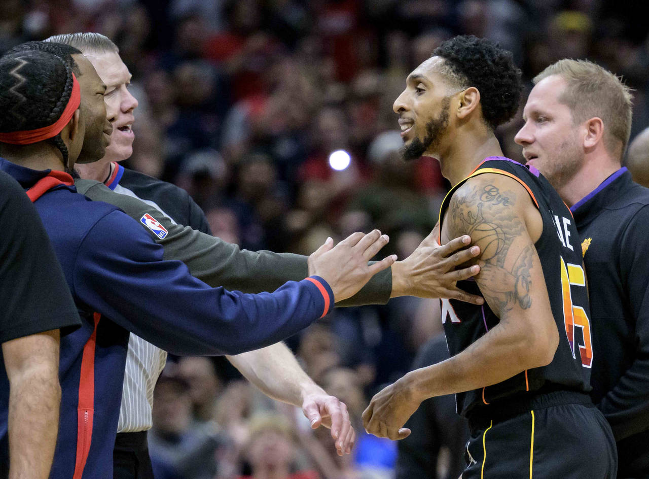 New Orleans Pelicans head coach Willie Green, second from left, puts his hand on Phoenix Suns guard...