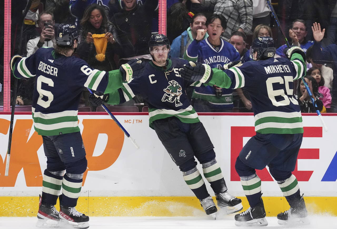Vancouver Canucks' Brock Boeser, Bo Horvat and Ilya Mikheyev, from left, celebrate Horvat's second ...