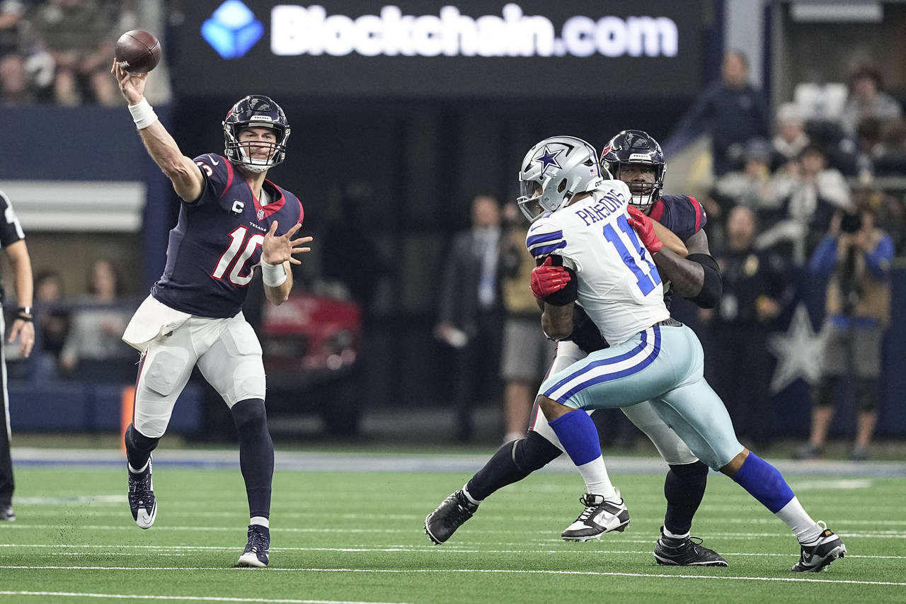 Houston Texans quarterback Davis Mills (10) throws a pass under pressure from Dallas Cowboys lineba...