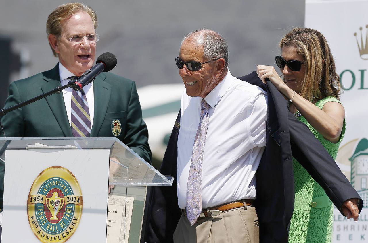 FILE - Monica Seles, right, helps Nick Bollettieri with a blazer as Hall of Fame chairman of the bo...