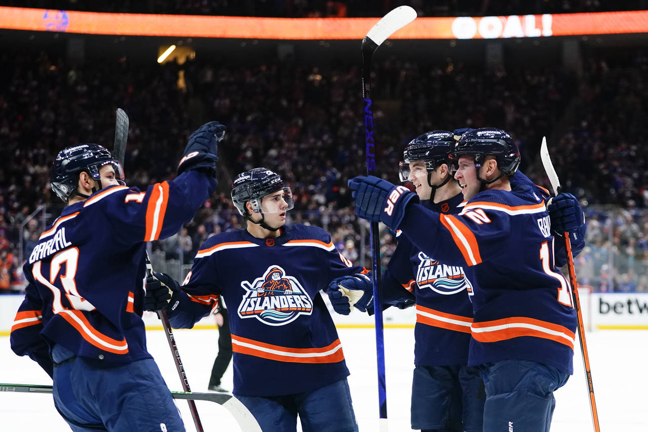 New York Islanders' Josh Bailey and Mathew Barzal celebrate with teammates after Bailey scored a go...