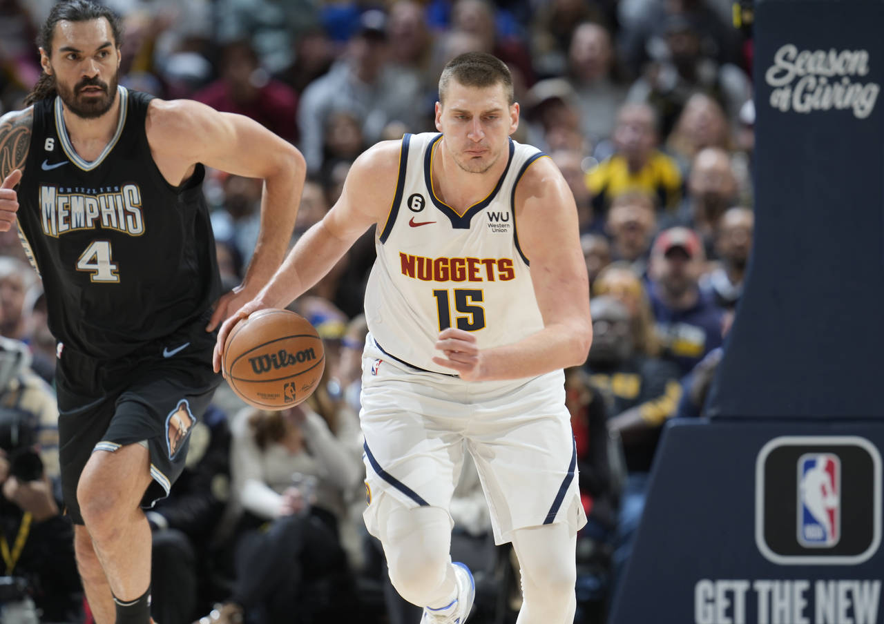 Denver Nuggets center Nikola Jokic, front, picks up a loose ball as Memphis Grizzlies center Steven...