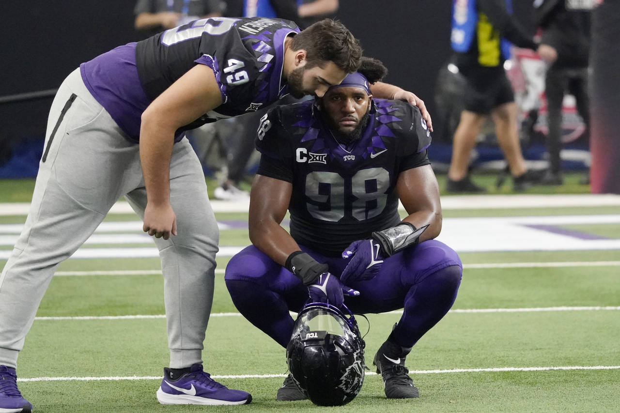 TCU's Connor Lingren (49) consoles teammate Dylan Horton (98) after Kansas State defeated them in t...