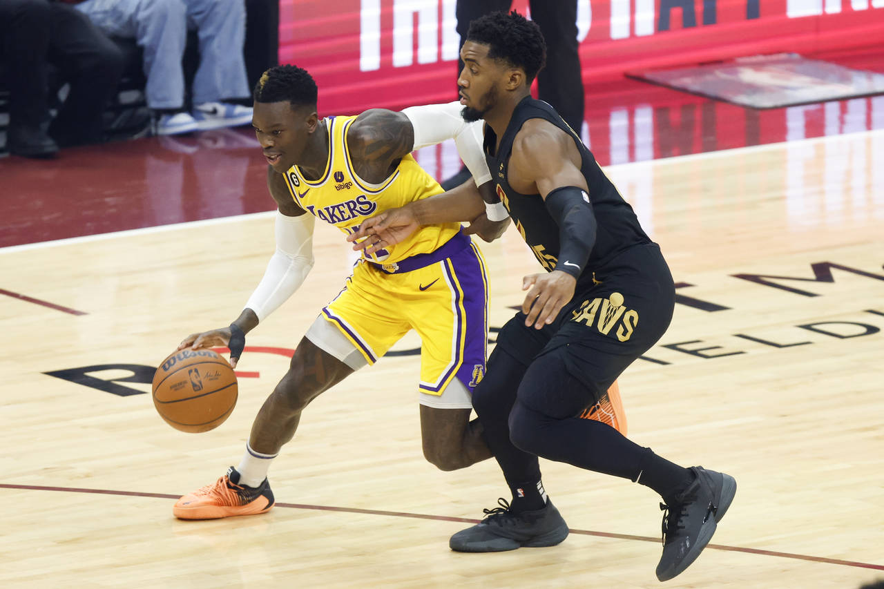 Los Angeles Lakers guard Dennis Schroder (17) drives against Cleveland Cavaliers guard Donovan Mitc...
