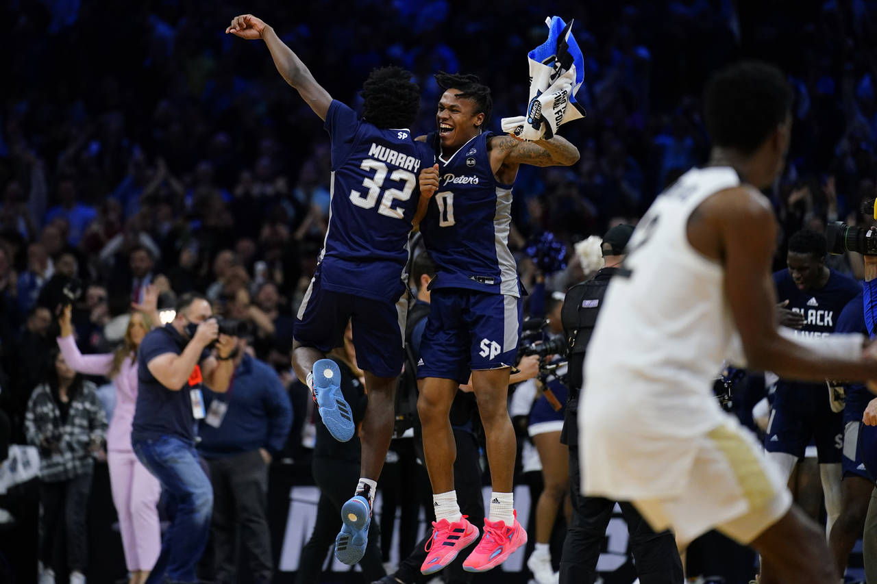 FILE - Saint Peter's Jaylen Murray, left, and Latrell Reid celebrate after their team won a college...