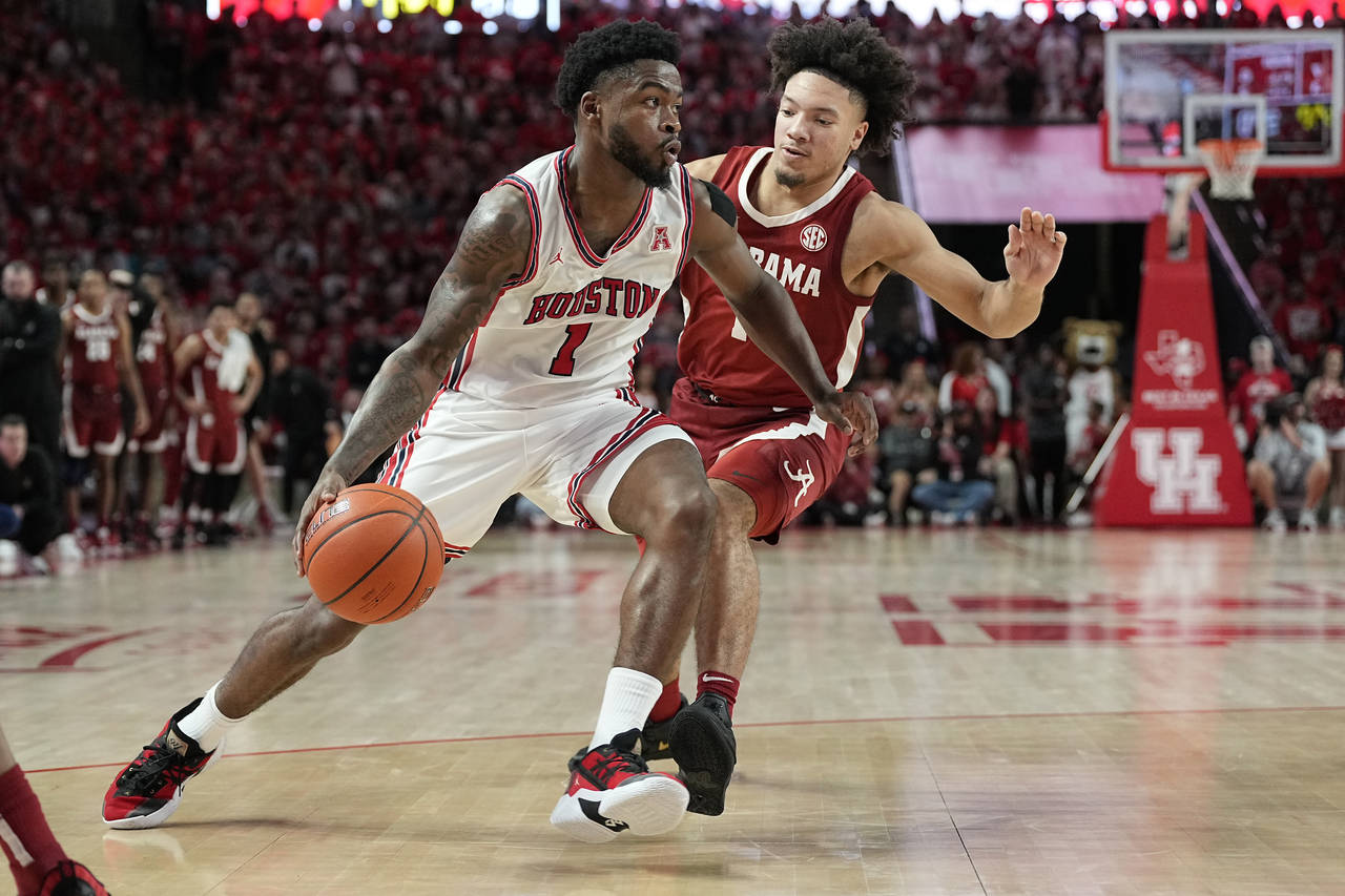 Houston guard Jamal Shead (1) drives past Alabama guard Mark Sears (1) on his way to score during t...