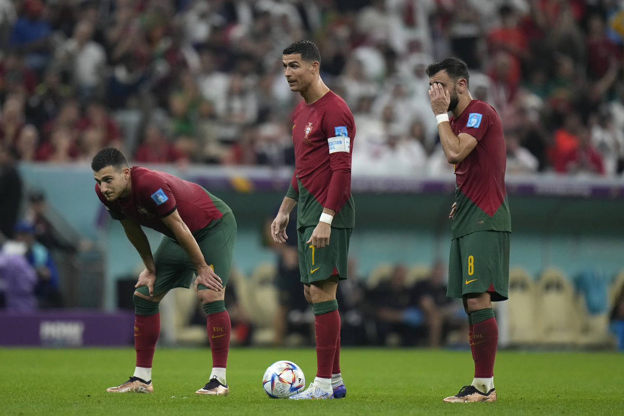 Portugal's Cristiano Ronaldo, center, stands with his teammates during the World Cup round of 16 so...