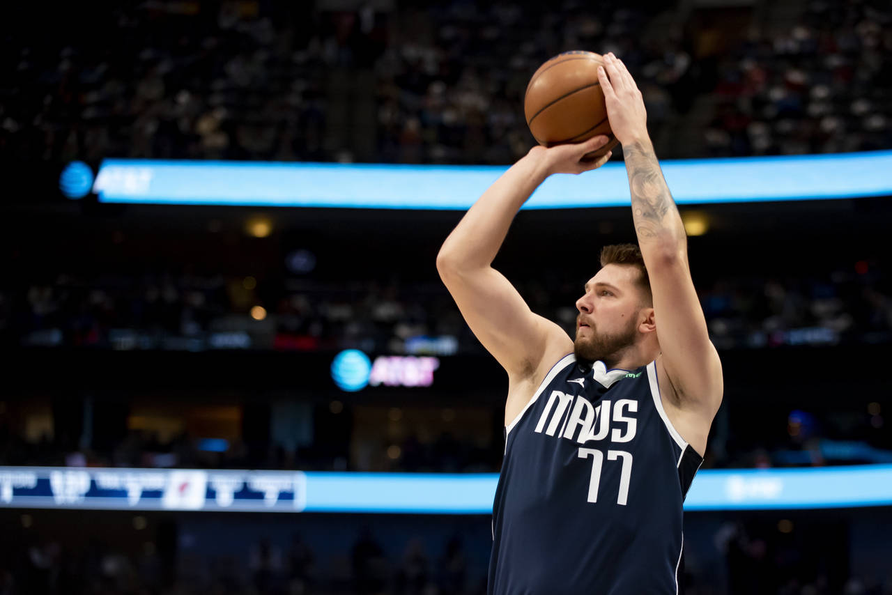 Dallas Mavericks guard Luka Doncic (77) shoots a 3-point basket in the first half of an NBA basketb...