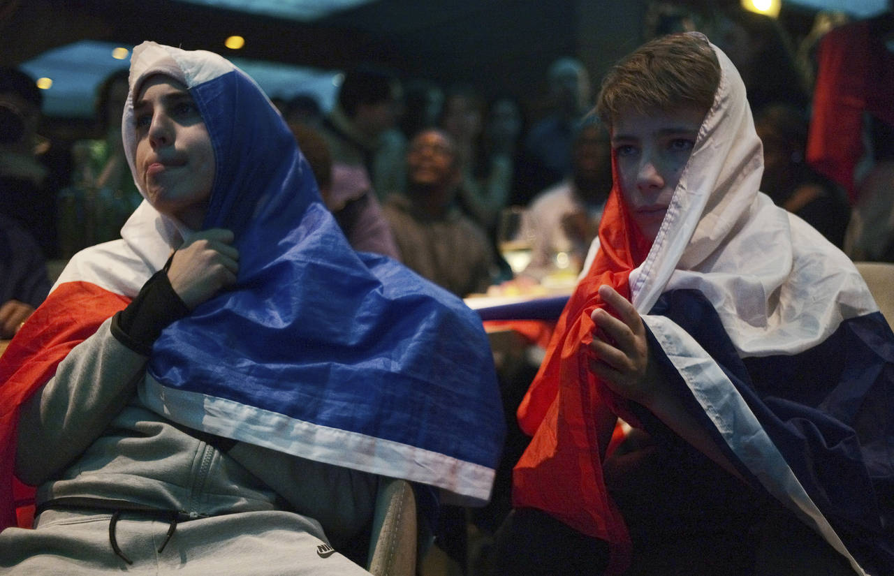 Disappointed French soccer fans react as they watch the World Cup final soccer match between Argent...