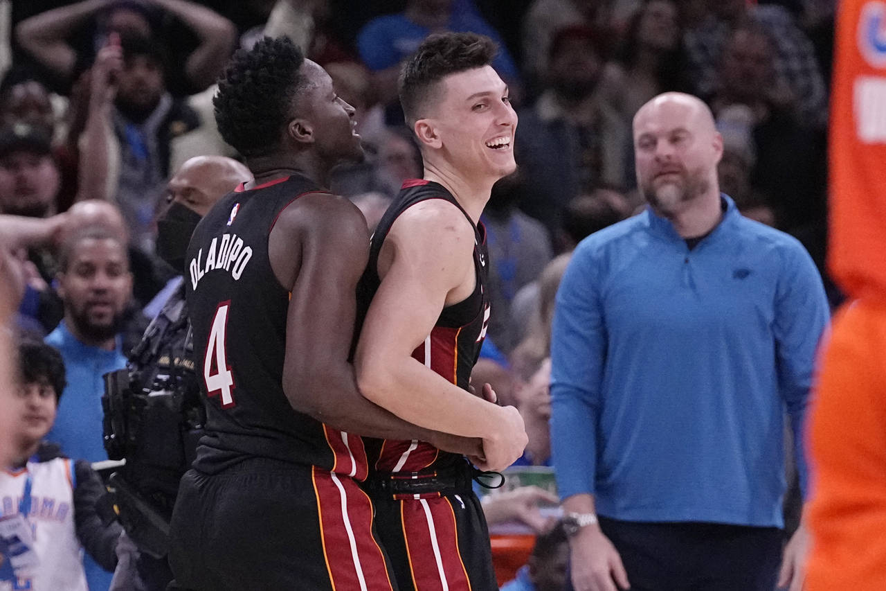 Miami Heat guard Tyler Herro, right, celebrates with teammate, Victor Oladipo, left, after the Miam...