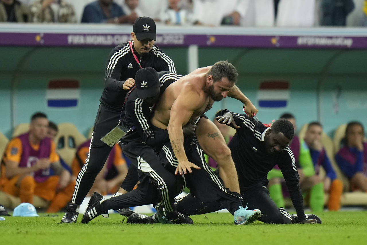 A pitch invader is tackled by security during the World Cup quarterfinal soccer match between the N...